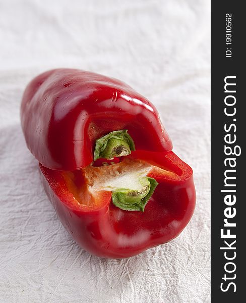 Sliced red pepper on white, showing pips and flesh, on fabric. Sliced red pepper on white, showing pips and flesh, on fabric.