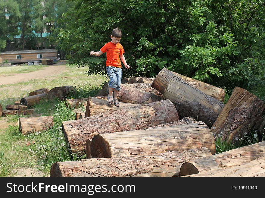 Boy entertaining by jumping over logs. Boy entertaining by jumping over logs.