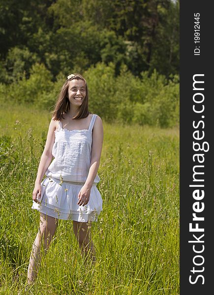 Young smiling girl walking in a meadow