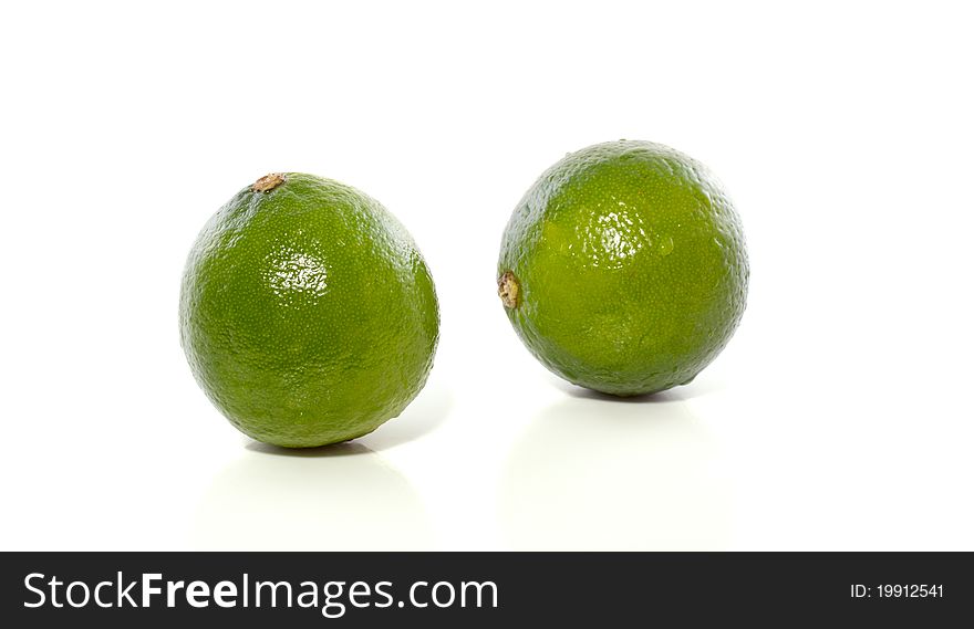 Macro image of two green healthy sour limes isolated over white background