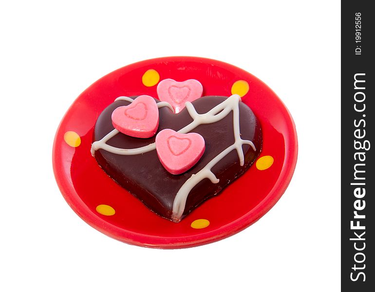 A lovely chocolate heart decorated white pink hearted candy on a ceramic little saucer isolated over white