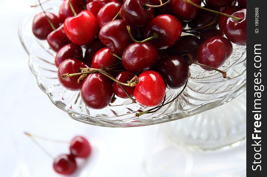 Sweet cherry in glass-ware on white background