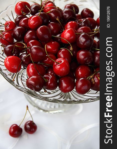 Sweet cherry in glass-ware on white background