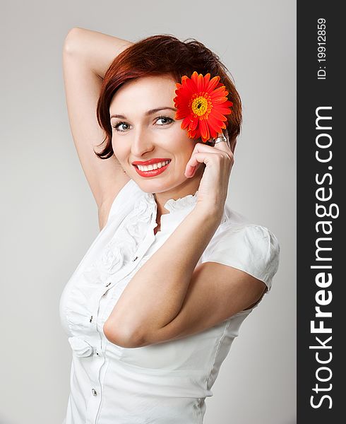 Beautiful woman with flower gerbera in her hands against white background. Beautiful woman with flower gerbera in her hands against white background