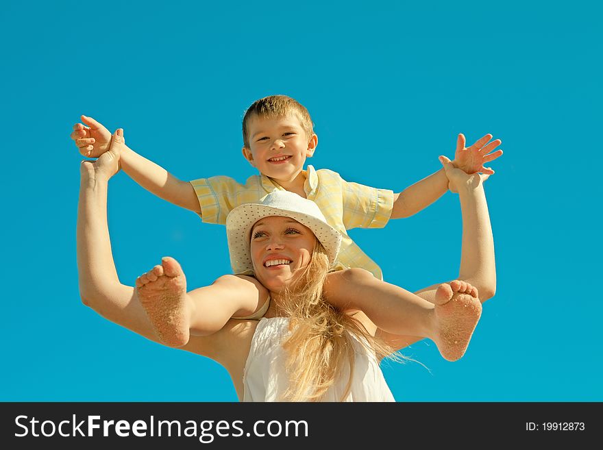 Beautiful young mother with son on the beach