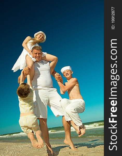 Father holding family on beach while on vacation. Father holding family on beach while on vacation