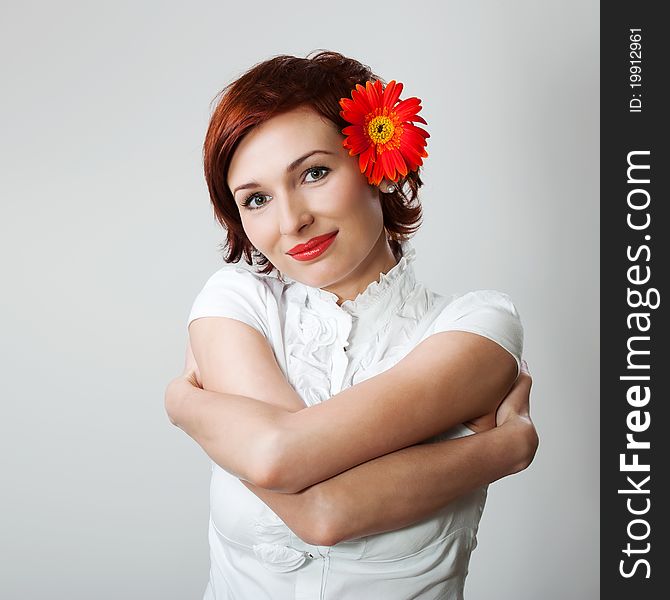 Beautiful woman with flower gerbera against white background