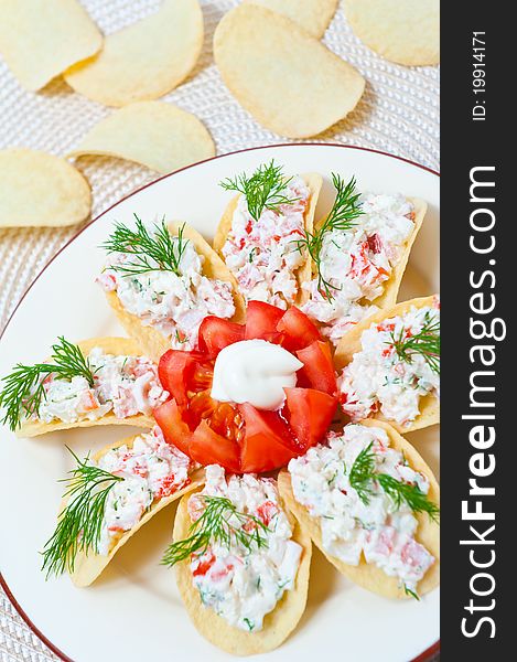 Appetizer on chips with crab meat, Feta cheese and tomato