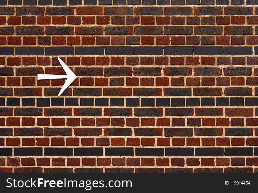 An arrow on a brick wall