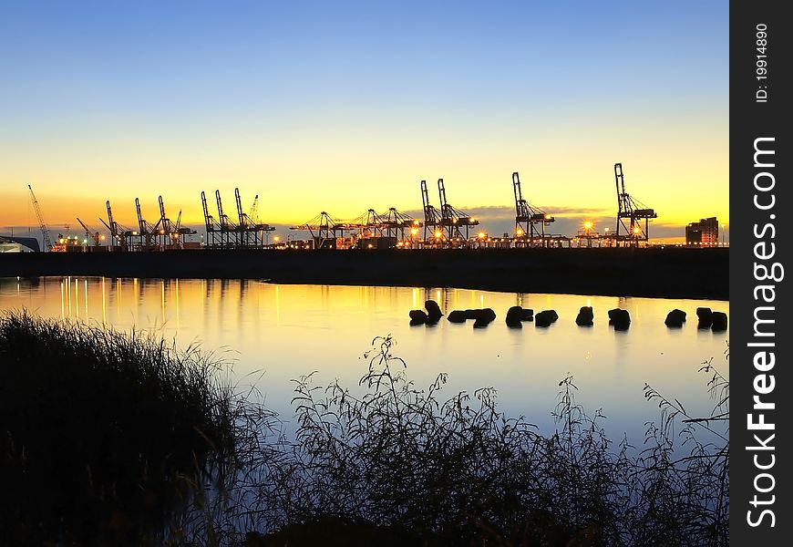 Sunset and crane in cargo wharf