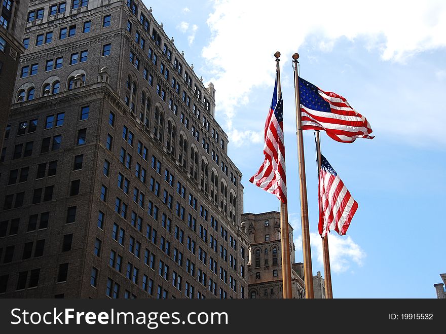 USA Flags swing in front of a New York building. USA Flags swing in front of a New York building