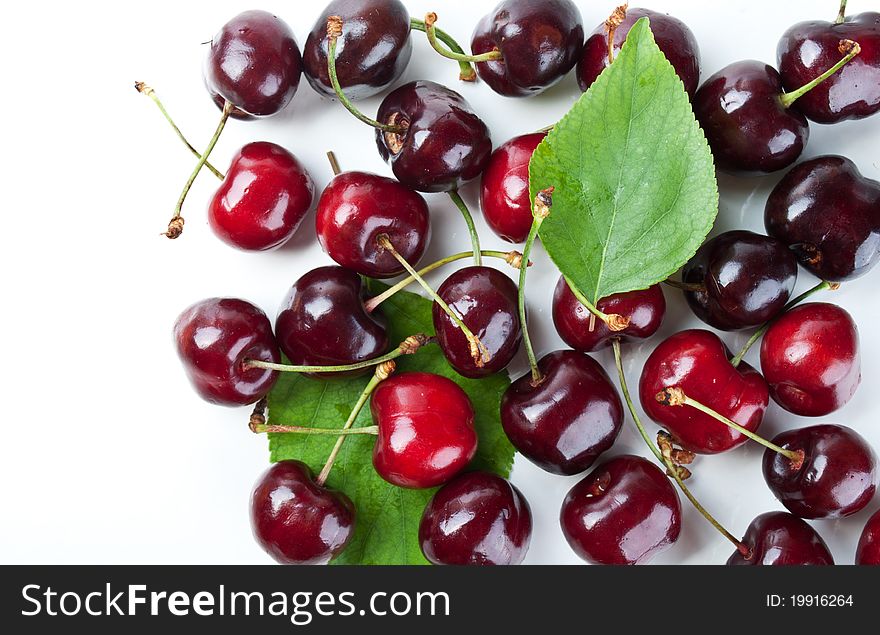 Fresh cherry and green leaf isolated on a white background