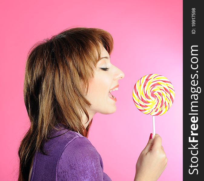 Portrait of girl with lollipop on pink background. Portrait of girl with lollipop on pink background