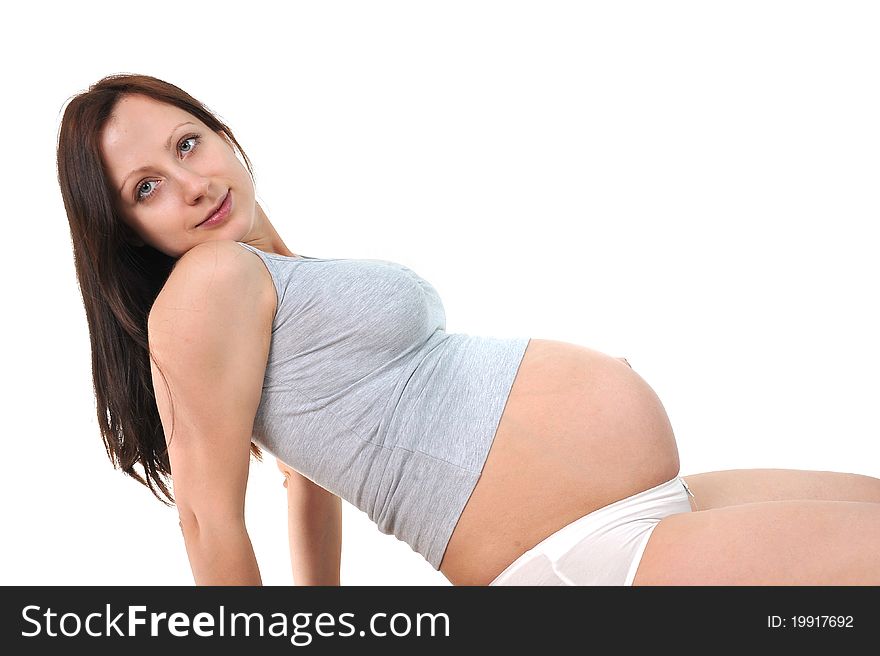 Pregnant woman sitting in living room smiling