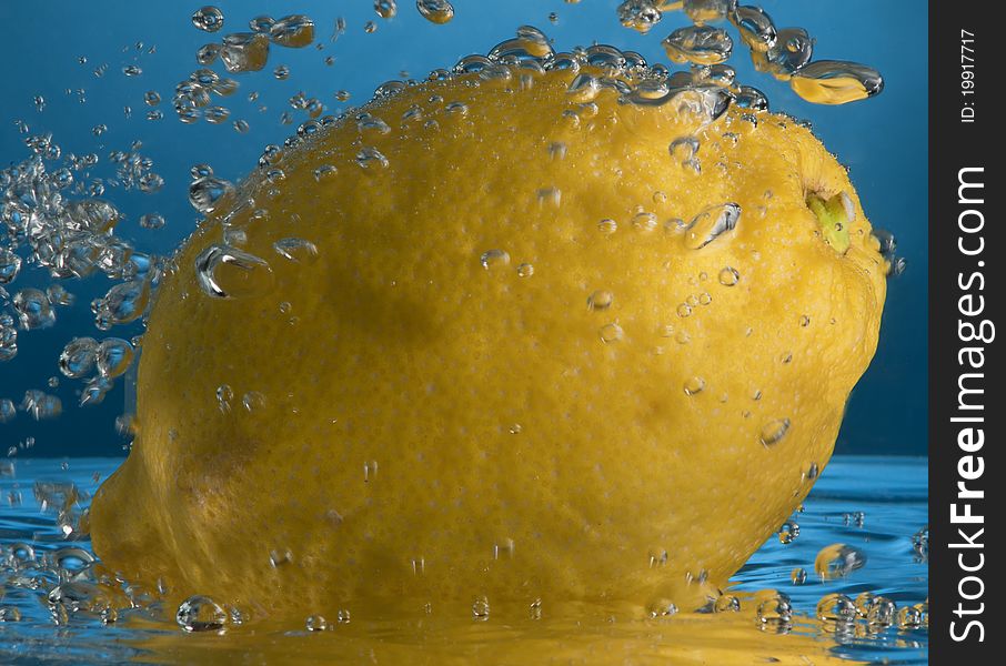 Lemon splash in water isolated on blue. Lemon splash in water isolated on blue