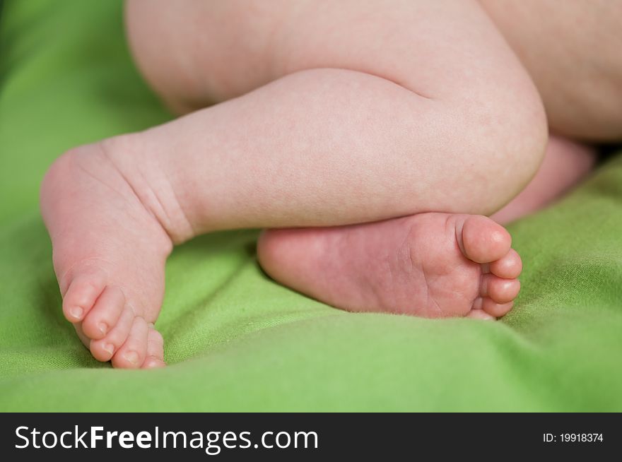 Newborn legs on green sheet