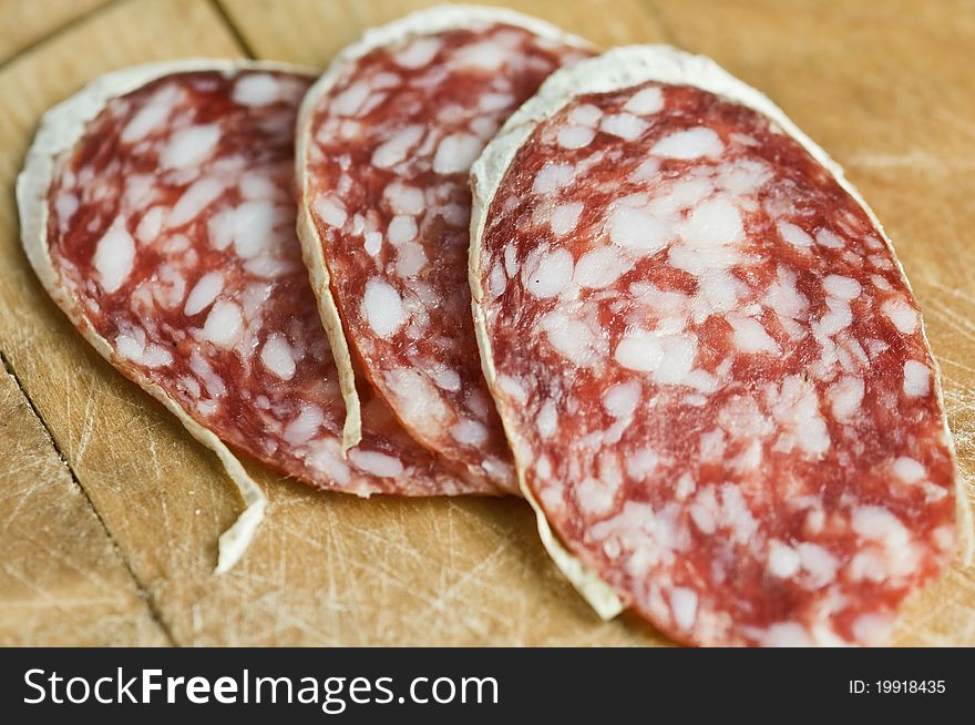 Salami pieces on wood table