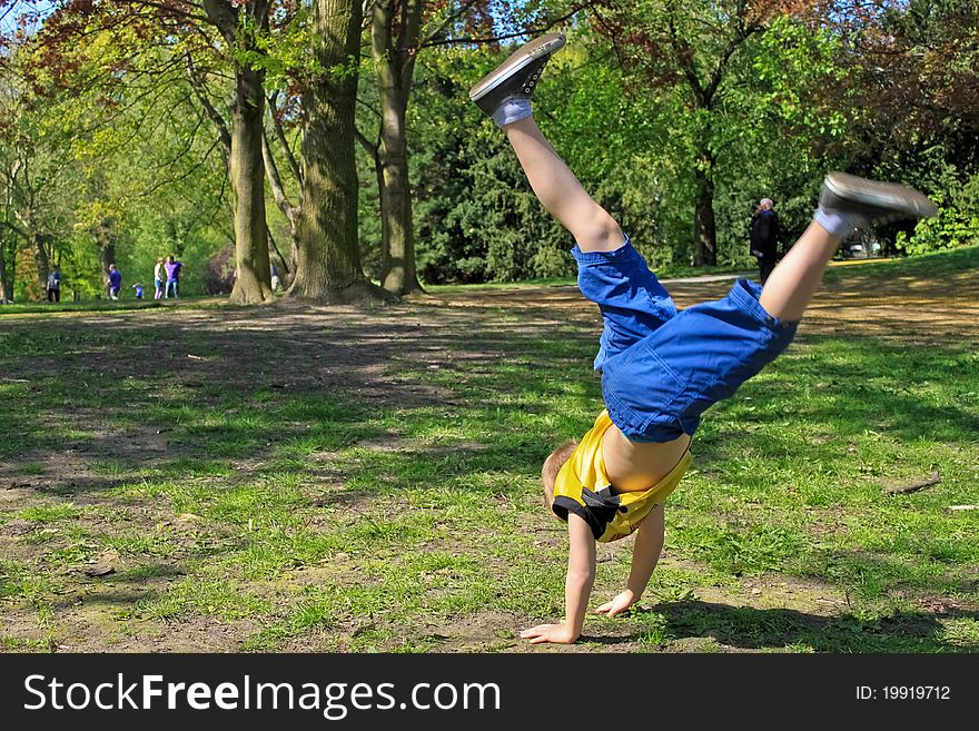 Boy doing handstand and acrobatic moves in a park. Boy doing handstand and acrobatic moves in a park