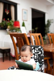 7 Month Old Asian Baby Girl Reading Lunch Menu Stock Photo