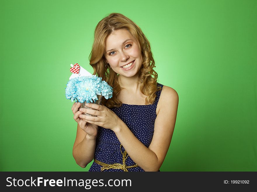 Close-up of an attractive young woman holding a gift bouquet of blue chrysanthemums. In flowers of a romantic note. Close-up of an attractive young woman holding a gift bouquet of blue chrysanthemums. In flowers of a romantic note