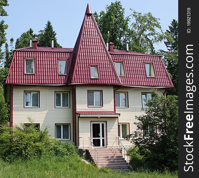 The three-storyed house with a tile roof costs in wood. The three-storyed house with a tile roof costs in wood