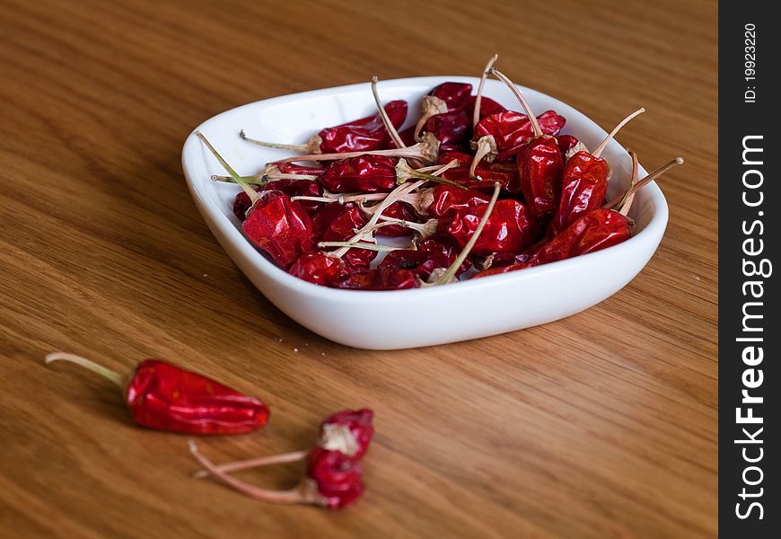 Chillies in a dish on a wood surface