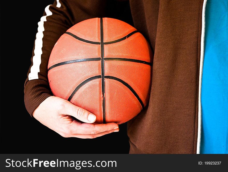 Man holding a basketball on a black background. Man holding a basketball on a black background