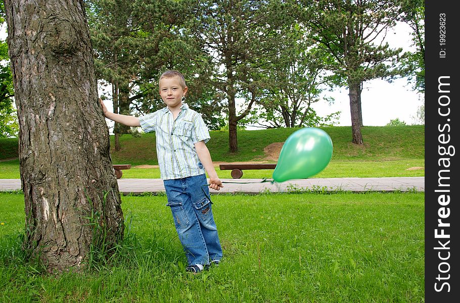 Child standing on the grass and holding a balloon