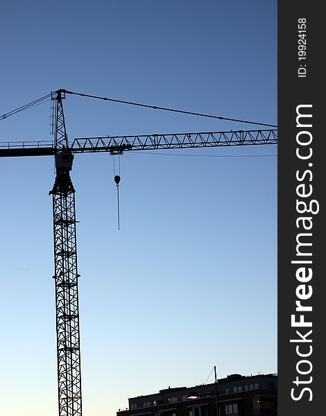 Silhouette of a crane at an apartment bulding site