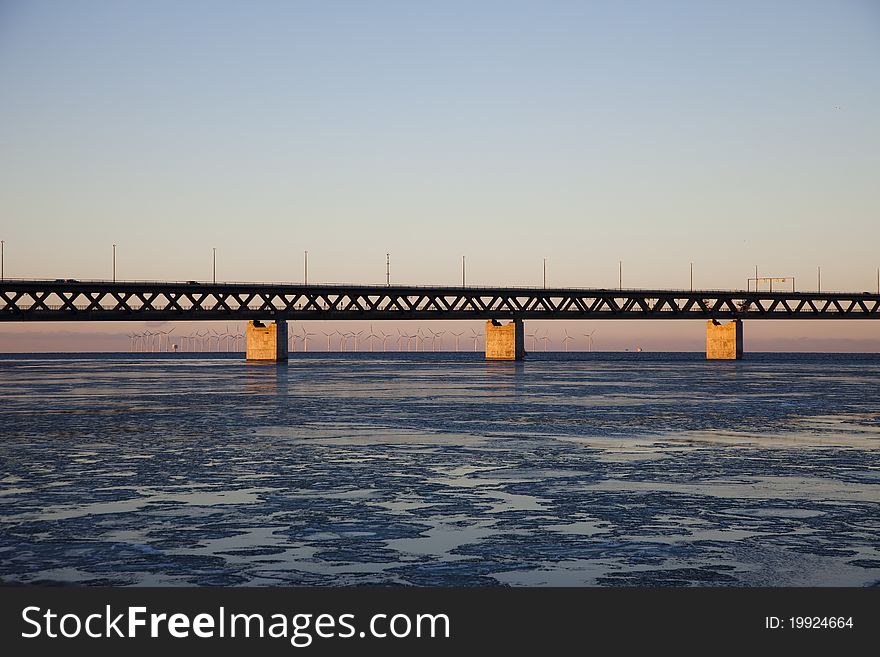 Oresund bridge viewed from land in sunset. Several wind turbines can be seen in the background. Oresund bridge viewed from land in sunset. Several wind turbines can be seen in the background