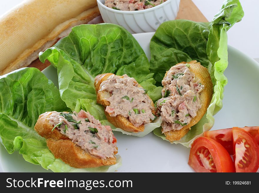 A plate of tuna pate with romaine lettuce and tomatoes as garnishing. A plate of tuna pate with romaine lettuce and tomatoes as garnishing