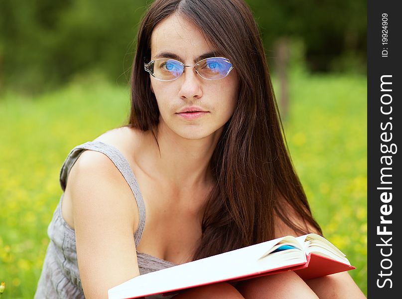 Young female with a book on a green meadow. Young female with a book on a green meadow