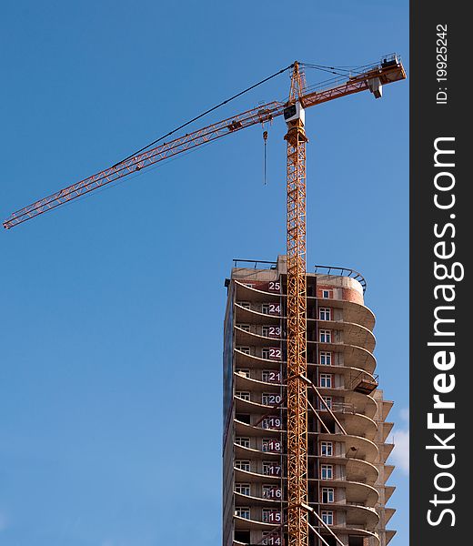 The building crane against the dark blue sky