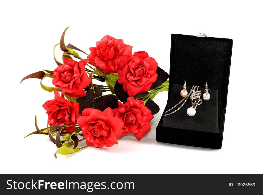 Precious pearls set in open gift box with red flowers