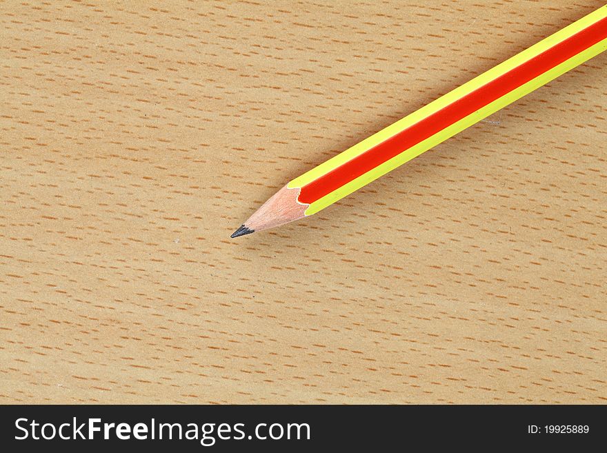 A pencil takes to write lay on wood ground