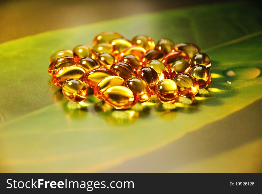 Yellow pills on green background, photography