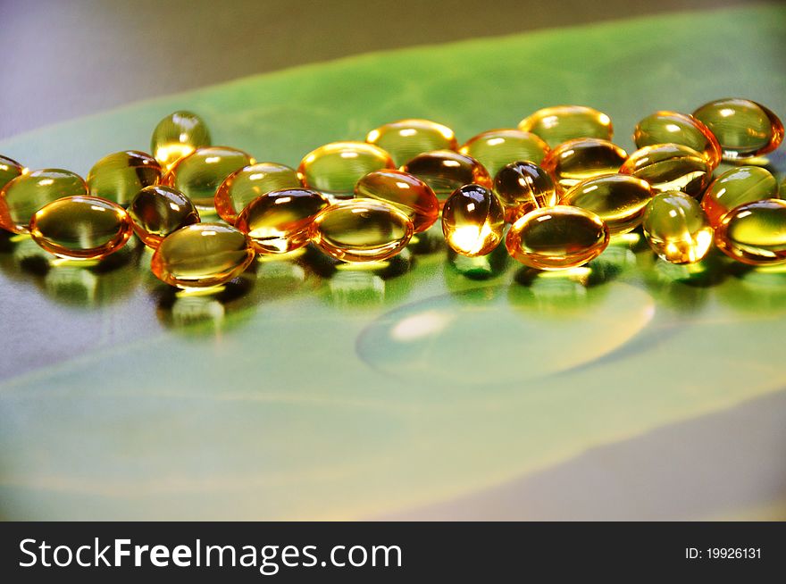 Yellow pills on green background