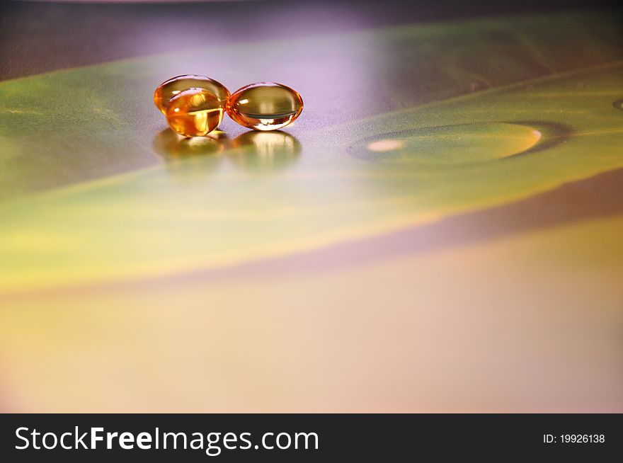 Yellow pills on green background, photography