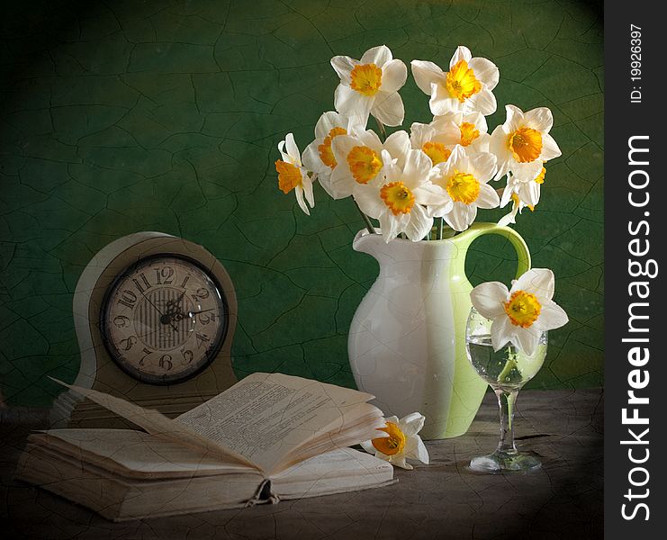 A bouquet of narcissuses, alongside clock and book