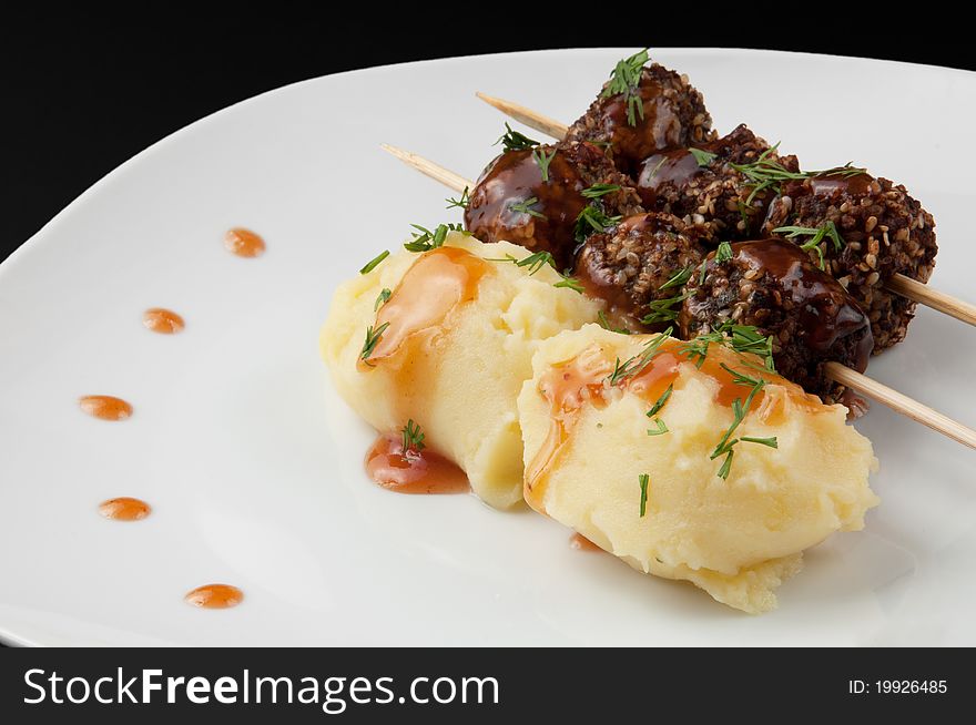 Mashed potatoes and meat balls and curry on white plate