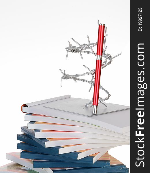 The barbed wire and a pen on note book stack