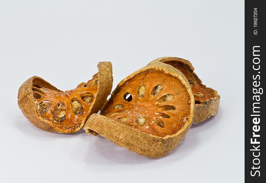 Slices of dried bael fruit on white background