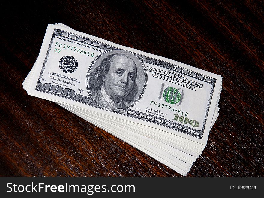 Bundle of dollar banknotes lying on a table surface. Bundle of dollar banknotes lying on a table surface