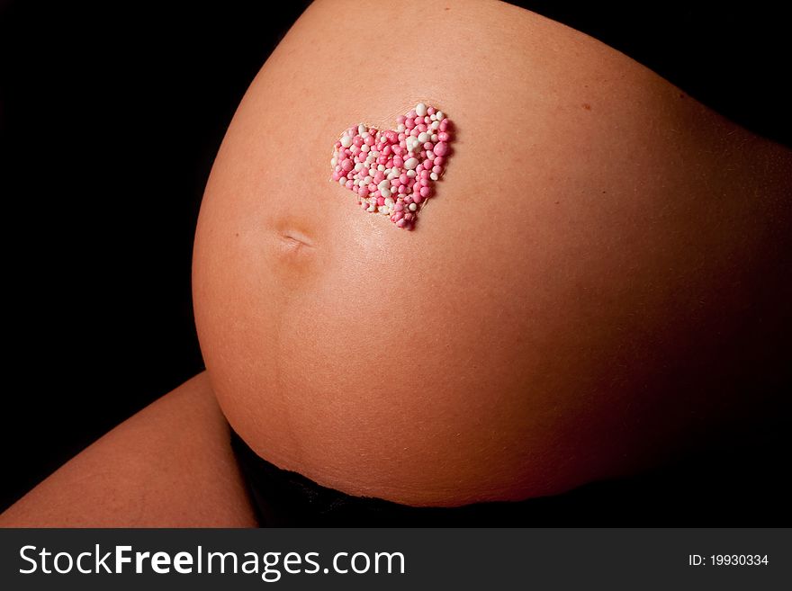 The belly of a pregnant woman with the shape of a hart on it. The belly of a pregnant woman with the shape of a hart on it