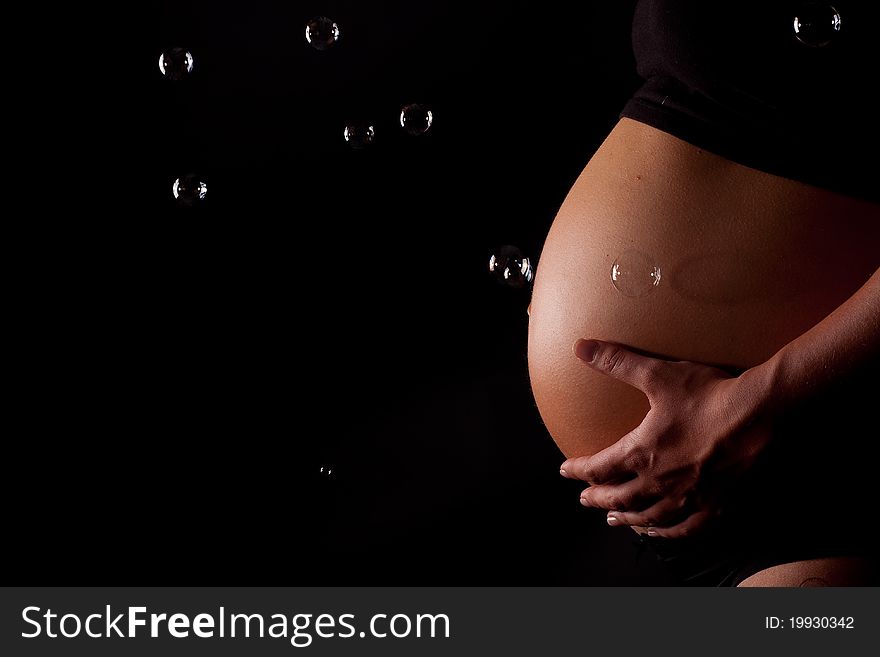 A beautifull close up of a pregnant belly with bubbles. A beautifull close up of a pregnant belly with bubbles