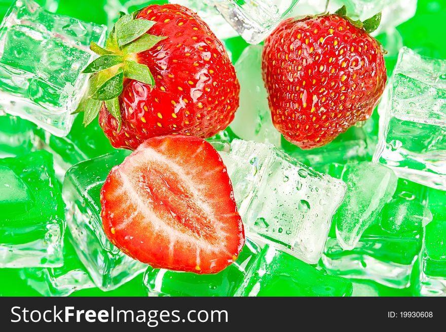 Fresh ripe strawberries with ice cubes on green surface. Fresh ripe strawberries with ice cubes on green surface