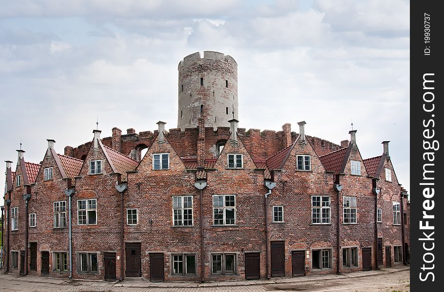 Old round castle with one tower, built with red bricks.