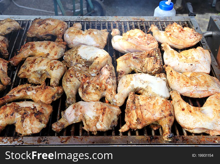 Chicken thighs on a BBQ grill during an outdoor event. Chicken thighs on a BBQ grill during an outdoor event