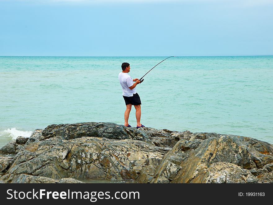 Fisherman on rocky to seacoast. Fisherman on rocky to seacoast