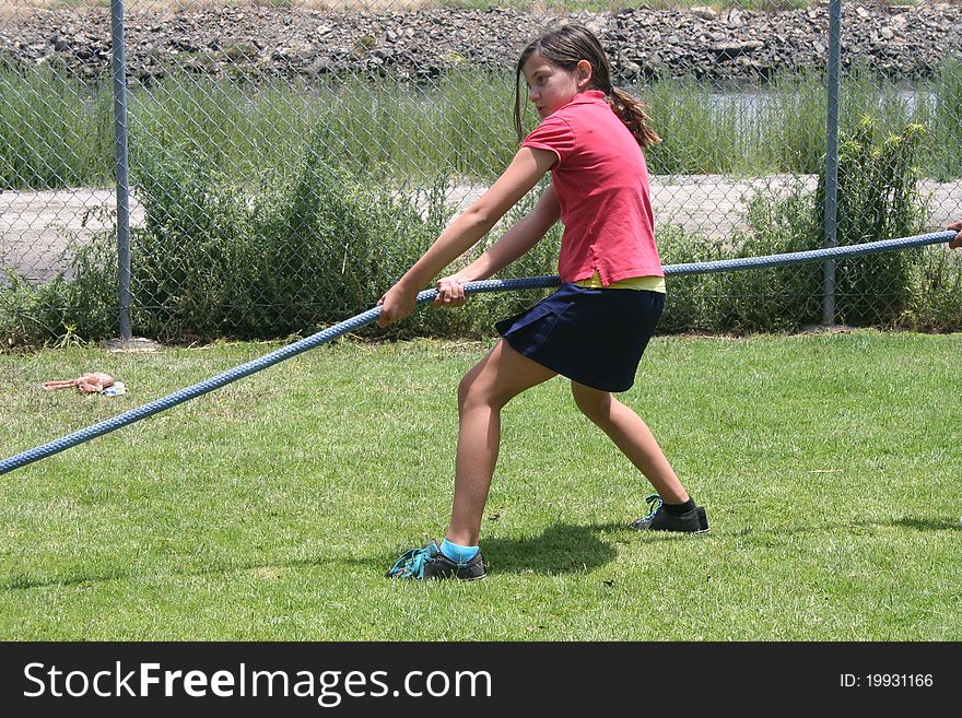 Girl pulling on a rope in a tug-o-war. Girl pulling on a rope in a tug-o-war.